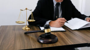 Lawyer is sitting on the table with gavel and writing