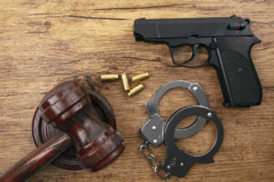 Gun, gavel and hands cuff on the table
