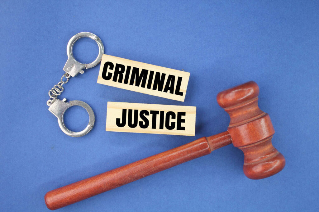 hand cuffs and gavel with criminal justice board